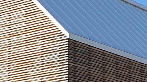 Detail skrytého okapního žlabu na bytovém domě z CLT panelů, se střechou TOPDEK a s dřevěnou fasádou